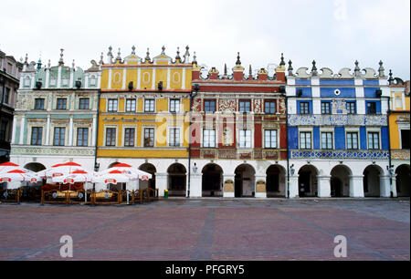 La Polonia, Cracovia, colore facciate di edifici e cafè sul marciapiede sulla piazza del mercato Foto Stock