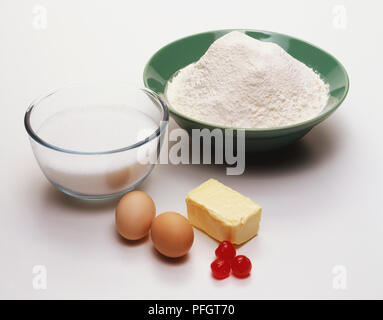 Ciotola di farina, latte, due uova, blocco di burro, glace di ciliegie, close up Foto Stock