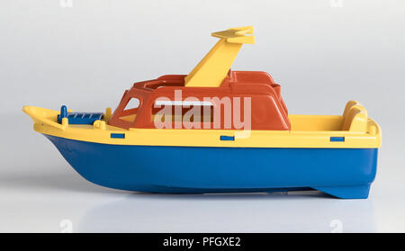 Una barca di plastica, colorato di rosso, giallo e blu. Foto Stock