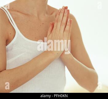 Donna con le mani in posizione di preghiera Foto Stock