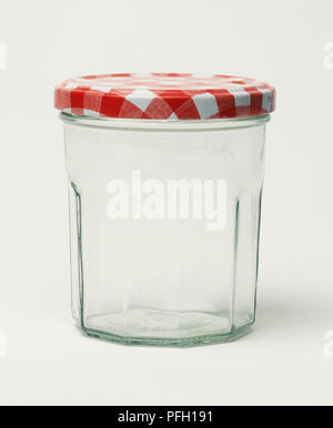 Il vasetto di vetro con il rosso e bianco coperchio in metallo Foto Stock