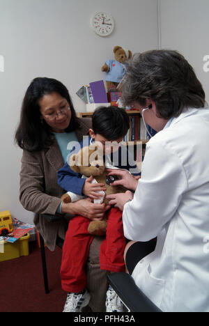 Ragazzo sulla donna di giro, medico donna holding stetoscopio per teddy Foto Stock