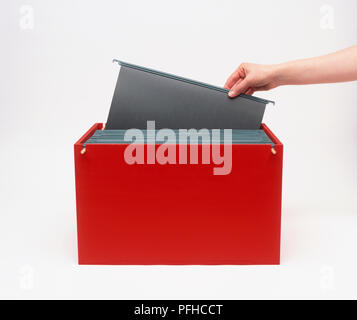 Persona ponendo mano singolo file appesi in riquadro rosso Foto Stock