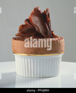 Souffle decorate con i riccioli di cioccolato in tazza, vicino. Foto Stock