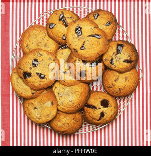 I biscotti al cioccolato su una griglia di raffreddamento su un panno striata Foto Stock