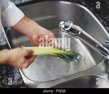 Il risciacquo dimezzato il porro levetta sotto corrente di acqua fredda Foto Stock