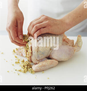 Il deflettore di sollevamento della pelle per farcire un pollo crudo Foto Stock
