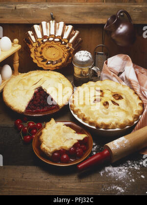 Cherry torte ingredienti grezzi e utensili da cucina su un tavolo di legno, ad alto angolo di visione Foto Stock