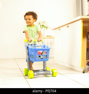 Ragazzo giocattolo di spinta carrello del supermercato. Foto Stock
