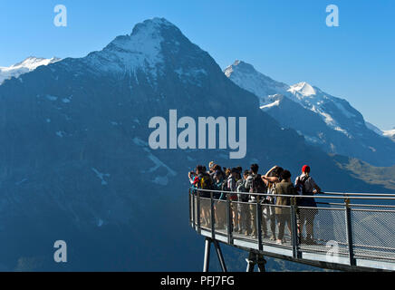 I turisti alla piattaforma di avvistamento guardando l'Eiger northface, prima scogliera a piedi da Tissot, Grindelwald, Svizzera Foto Stock