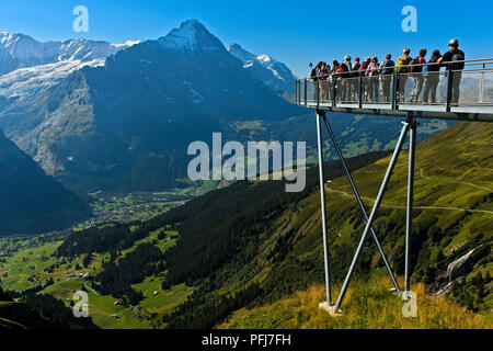 I turisti alla piattaforma di avvistamento alta sopra Grindelwald nella valle, Eiger northface dietro, prima scogliera a piedi da Tissot, Grindelwald, Svizzera Foto Stock