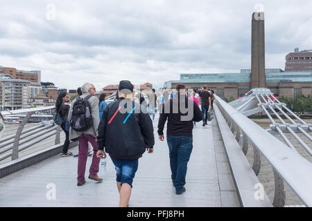 Pedoni camminare sul Millennium Bridge di Londra che guarda verso la Tate Modern a Bankside Foto Stock