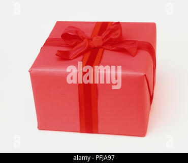 Box avvolto in carta rossa e nastro rosso Foto Stock