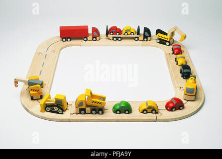 Modellini di auto e camion su strada circolare di legno Foto Stock
