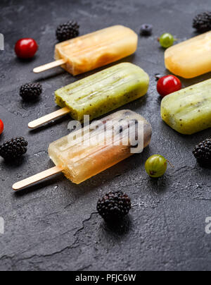 Foto di frutta congelata di ghiaccio su bastoni e bacche Foto Stock