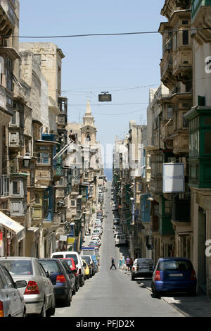 Malta, La Valletta, Triq San nottolino, fermo vetture schierando stretti di san Paolo la strada che conduce al mare Foto Stock