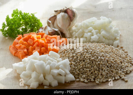 Ingredienti per la zuppa di verdure, compreso un trito di carote e cipolle, prezzemolo fresco, aglio e semi di orzo, close-up Foto Stock