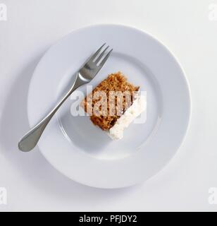 Fetta di torta di carote sulla piastra bianca con forca Foto Stock