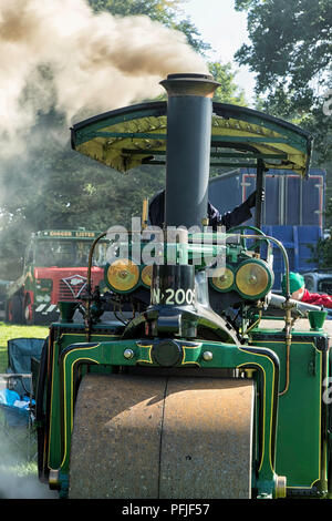 Old Steam Roller alla fiera del vapore di Harewood con nuvole di fumo che escono dal camino, West Yorkshire, Inghilterra, Regno Unito. Foto Stock