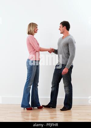 L uomo e la donna in abiti casual stringono le mani Foto Stock