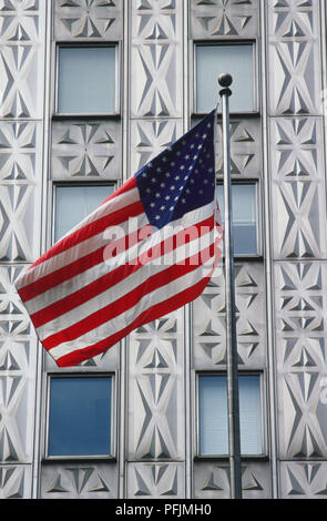 Stati Uniti d'America, New York Manhattan Midtown inferiore, Mobil edificio, noi battenti bandiera nella parte anteriore in acciaio inossidabile facciata scolpita con motivo geometrico, vicino. Foto Stock