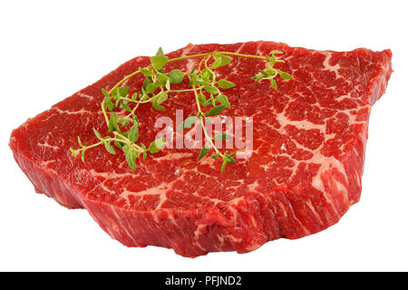 Crudo fresco marmo succosa bistecca di manzo condito con timo isolati su sfondo bianco, vista laterale dal di sopra, close-up Foto Stock