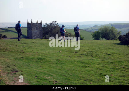 Tre gli escursionisti a piedi passato San Giovanni Battista in Countisbury sul sud-ovest sentiero costiero, Devon, Inghilterra, Regno Unito. Foto Stock