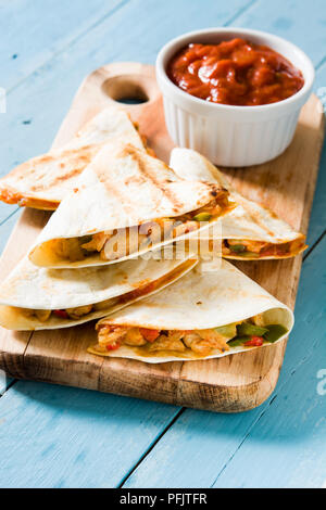 Mexican quesadilla con pollo, formaggio e peperoni blu sul tavolo di legno. Foto Stock