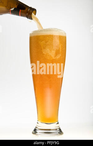 Birra di frumento che viene versato dal flacone, close-up Foto Stock