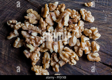 I gherigli di noci sul tagliere di legno sfondo direttamente dal di sopra Foto Stock