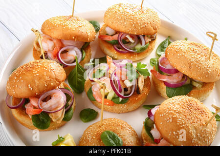 Deliziose grigliate hamburger succosa segnato con gli spiedini di bambù o pinchos con frutti di mare, cipolla rossa e verde su bianco piatto sul tavolo di legno, Spagna cuisi Foto Stock