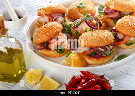 Grigliate gli hamburger succosa segnato con gli spiedini di bambù o pinchos con frutti di mare - Gamberetti, cozze, strisce di calamari, cipolla rossa e gli spinaci sul piatto bianco, Spagna Foto Stock