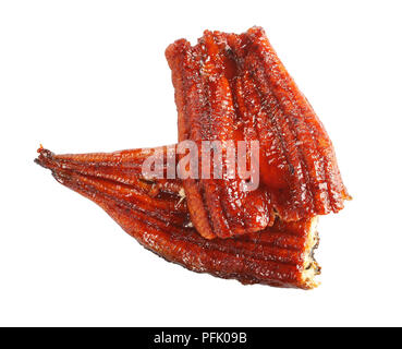 Due pezzi di grigliate di unagi filetto o anguilla con salsa di soia isolata su sfondo bianco, cucina asiatica, close-up, orizzontale vista da sopra Foto Stock