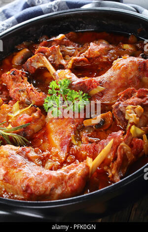 Delizioso stufato di coniglio con il porro, verdure, erbe e funghi nel piatto di ceramica sul vecchio legno scuro tabella, natale cena di gala ricetta, verticale Foto Stock