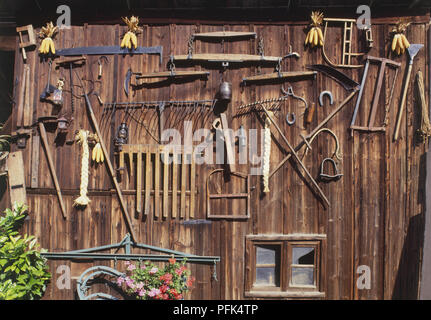 Francia, Alsazia, Eguisheim, viticoltori del cortile, strumenti appeso su legno Foto Stock