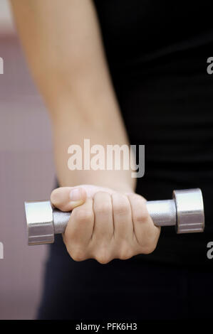 Giovane donna tenendo il manubrio in pugno chiuso, close-up Foto Stock