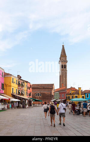 Tramonto nel colorato villaggio di pescatori sull'isola di Burano, Venezia, Veneto, Italia. Via Baldassare Galuppi, la principale strada con i negozi, turisti e res Foto Stock