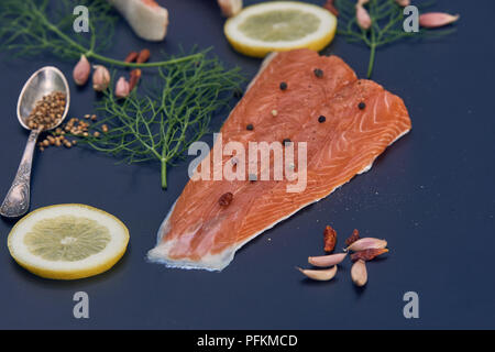 Salmone con le fette di limone aneto peperoncino aglio Foto Stock