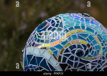 Close up del mosaico giardino palla in variopinte tonalità di blu realizzato da colorate piastrelle in vetro, disegno astratto che illustra il flusso di acqua Foto Stock