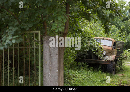 Vecchio camion dell'esercito russo abbandonato parcheggiato contro gli alberi in Bulgaria Foto Stock