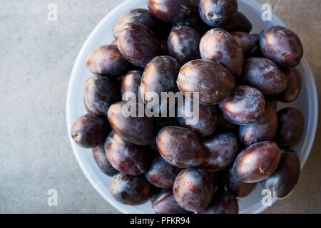 Damson prugne in coppa in plastica. Alimenti biologici. Foto Stock