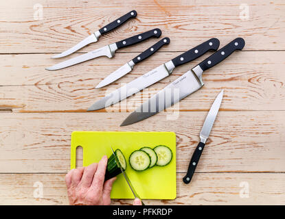 Un assortimento di vari coltelli da cucina su un sfondo di legno. Foto Stock