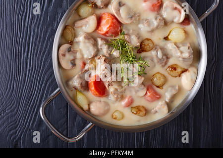 Cremosa di spezzatino di vitello o blanquette di vitello - pezzi di carne di vitello spalla stufati con funghi, smaltate cipolline, erbe e verdure in una casseruola Foto Stock