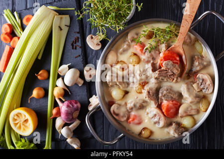 Cremosa di spezzatino di vitello o blanquette di vitello - pezzi di carne con funghi, smaltate cipolline, erbe e legumi stufati con salsa cremosa in casse Foto Stock