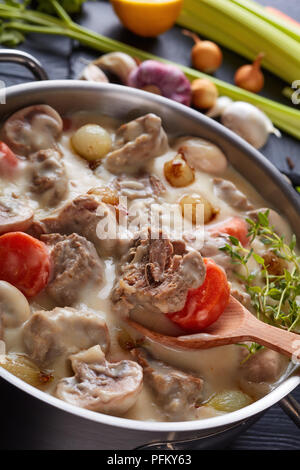 Blanquette di vitello - pezzi di calvish di carne con funghi, cipolline, erbe,legumi stufati con salsa cremosa in una casseruola. ingredienti a bac Foto Stock