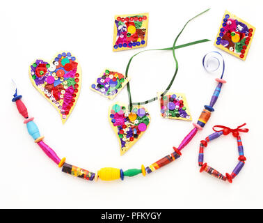 Cuore - e a forma di diamante e ciondoli decorate con paillettes, una collana e un bracciale realizzato con perline di legno Foto Stock