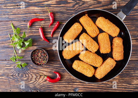 Deliziosa spagnolo crocchette di patate, croquetas su una padella su una tavola in legno rustico, vista da sopra Foto Stock