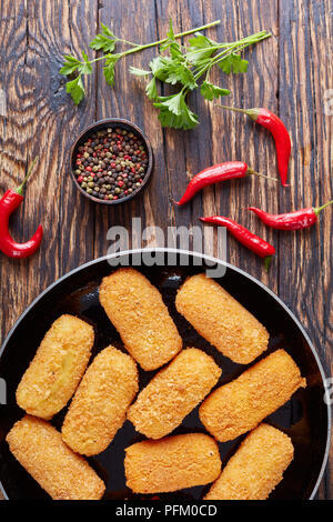 Deliziosa spagnolo fritte crocchette di patate, croquetas su una padella su una tavola in legno rustico, vista da sopra, close-up Foto Stock