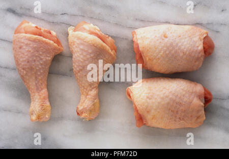 Un trito di cosce di pollo su granito superficie di lavoro, vista aerea. Foto Stock