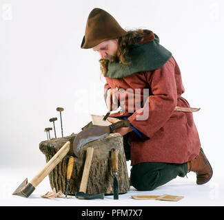 Falegname medievale scalpello di contenimento sul ceppo di albero Foto Stock